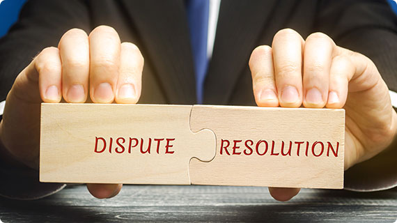 Hands holding puzzle pieces labeled dispute resolution, symbolizing legal conflict resolution services.