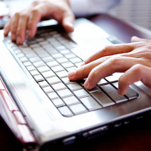 Hands typing on a laptop, representing online mediation services for legal disputes.