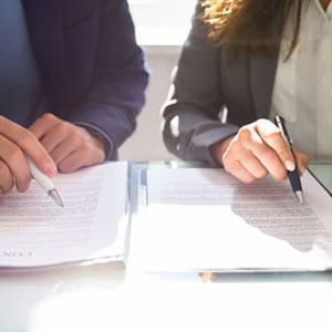 Two professionals reviewing documents during a business mediation in Rosemont, CA.
