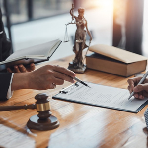 Lawyer guiding a client signing a mediation agreement in Placer County, CA law office.