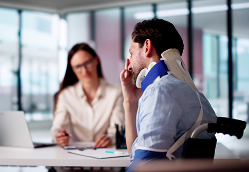 Injured man in neck brace meeting with lawyer for personal injury mediation consultation
